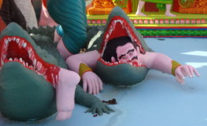alligator eats man statue